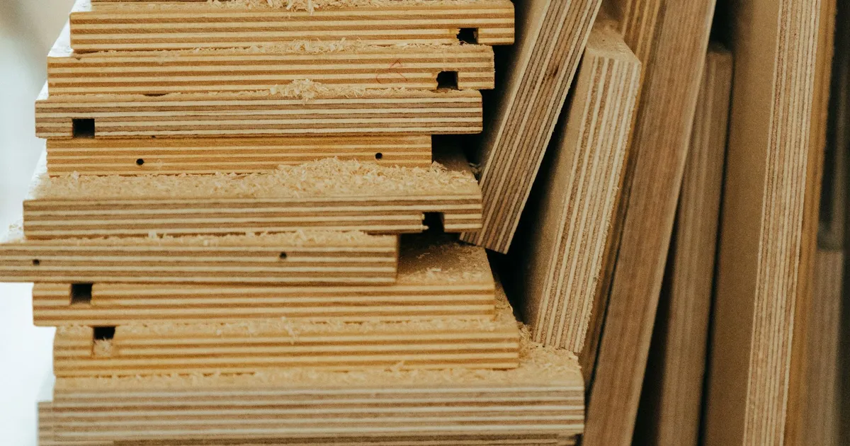 Stack of plywood offcuts seen from the edge, showing the alternating veneer layers and glue lines that a bond test examines