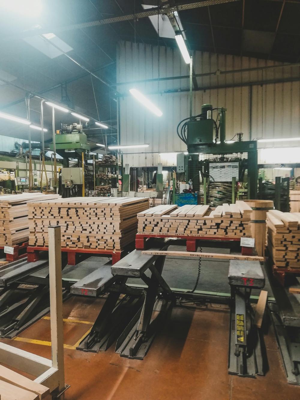 Plywood mill production floor with panels stacked beside the press line